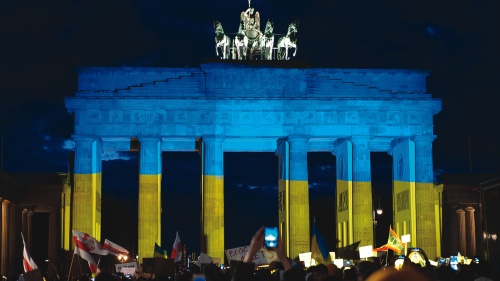 German protestors demonstrate in solidarity with Ukraine in front of the famous Brandenberg gate in Berlin, which is bathed in the colors of the Ukrainian flag.