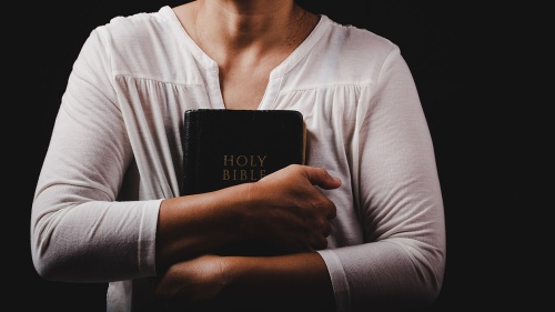 A woman holding a Bible.